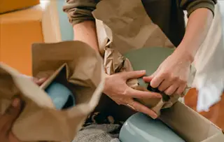 person wrapping ceramic items for packing